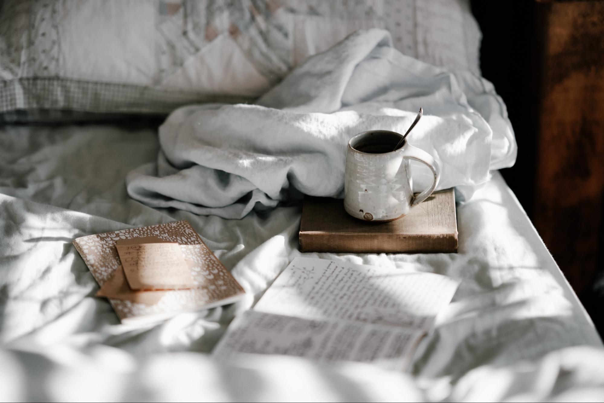 bed with book journal notes and tea