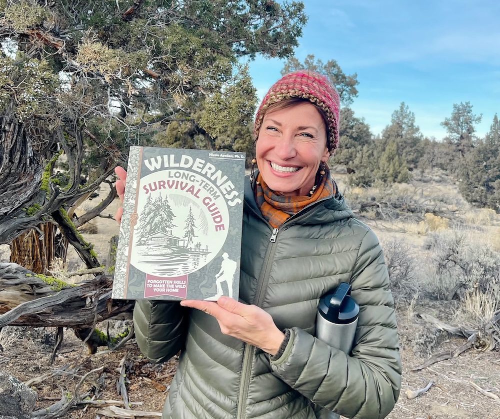 Nicole Apelian holding her Wilderness Long Term Survival Guide