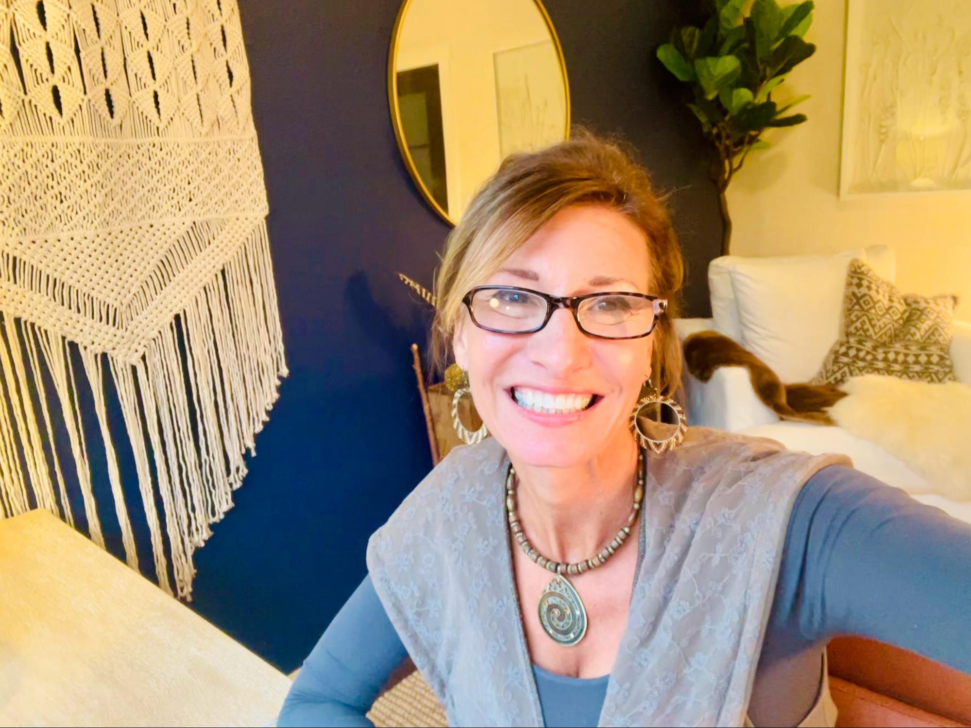 Nicole Apelian posing in front of macrame wallhanging
