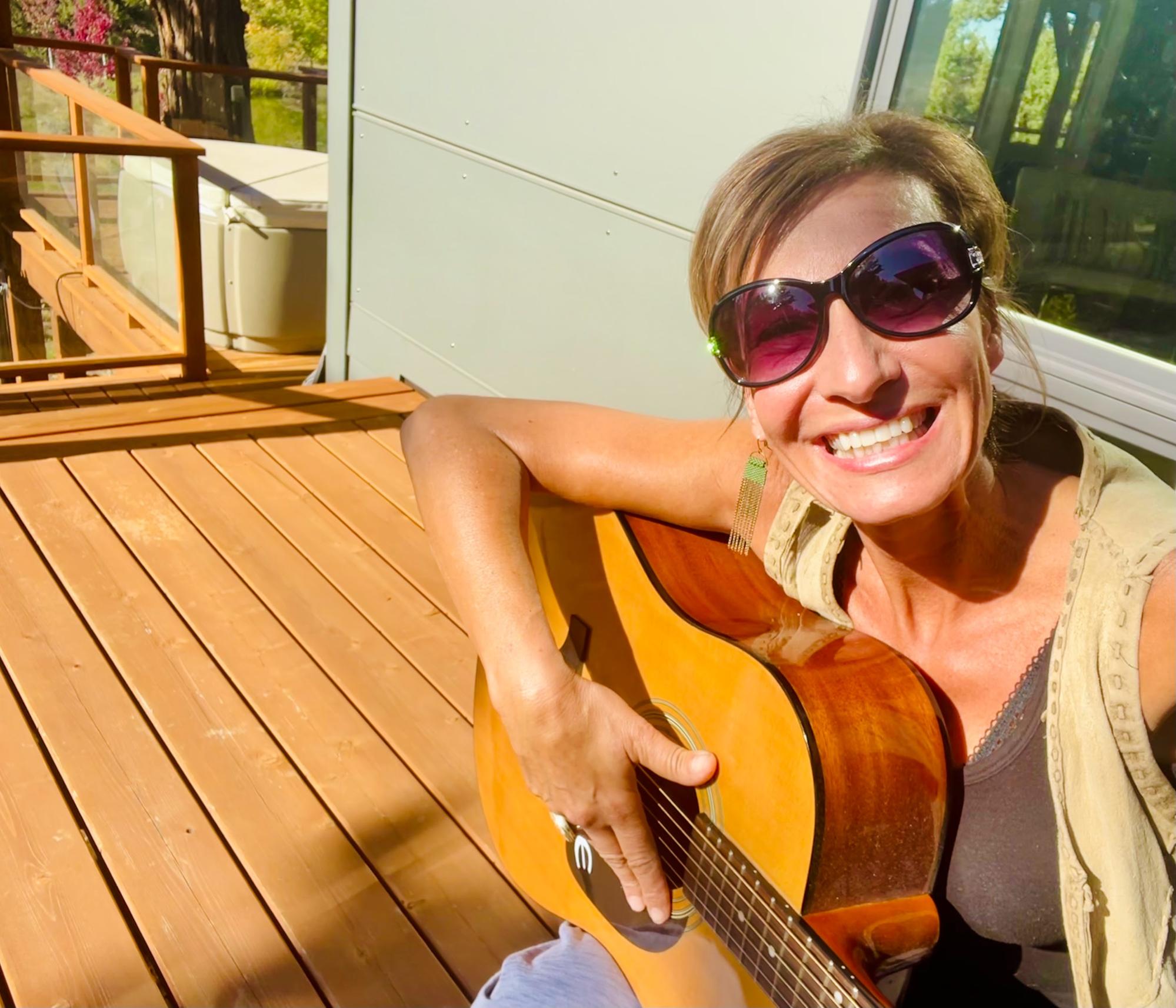 Nicole Apelian playing guitar on her deck