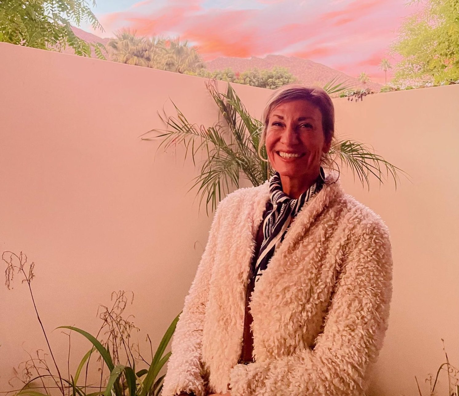 Nicole Apelian in a courtyard under pink clouds