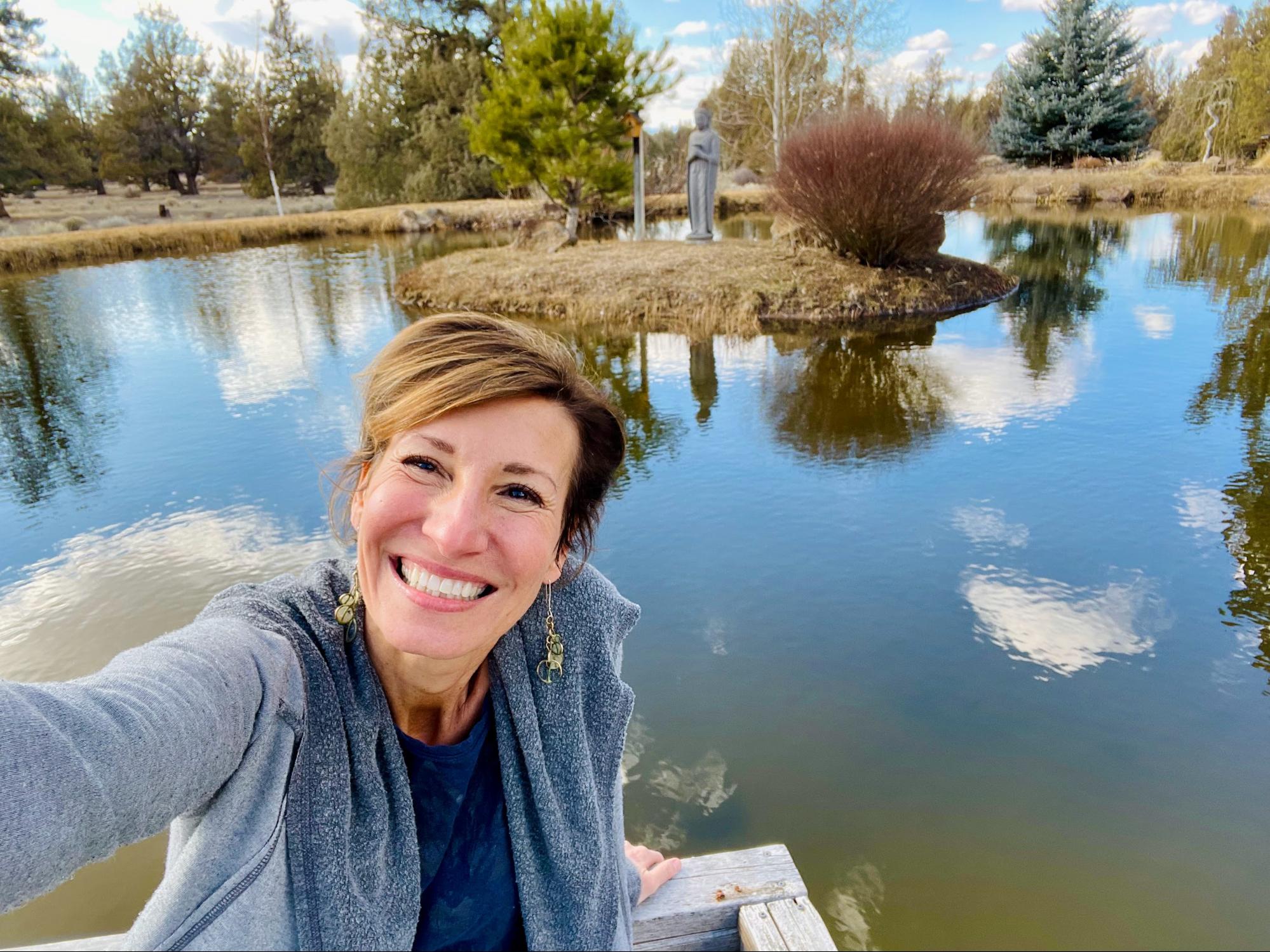 Nicole Apelian at pond reflecting the sky and clouds
